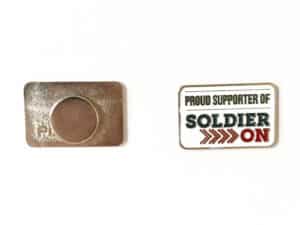 Front and back of rectangular enamel lapel pin. The front is white with the words proud supporter of Soldier On in dark grey and red. The back shows a magnet clasp.