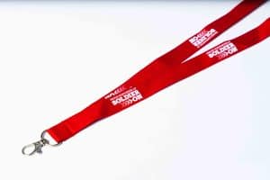 Red lanyard with text that reads proud supporter of Soldier On in white .