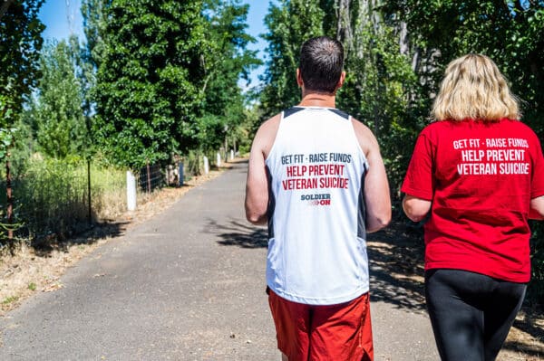Back of March On running singlet and red t-shirt. Text on both tops reads get fit, raise funds, help prevent veteran suicide. The running singlet also has the Soldier On logo under the text.